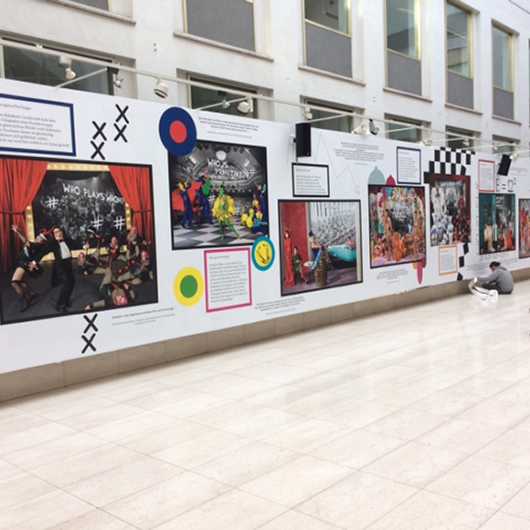 Messe Event: Kunstausstellung mit Fotos und Grafiken an einer Wand.