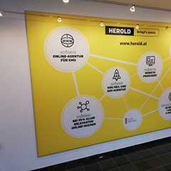 Wechselrahmen: Gelbes Werbebanner von Herold.at für Online-Agentur KMU. Bilderrahmen.