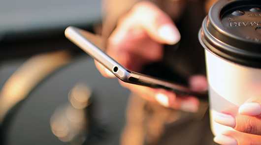 Kontakt: Handy in der Hand, Kaffeebecher. Fragen? Hier Antworten finden!