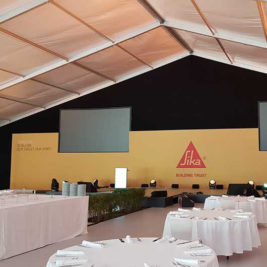 Indoor-Event: Sika Bühne mit Tischen. Firmenveranstaltung.