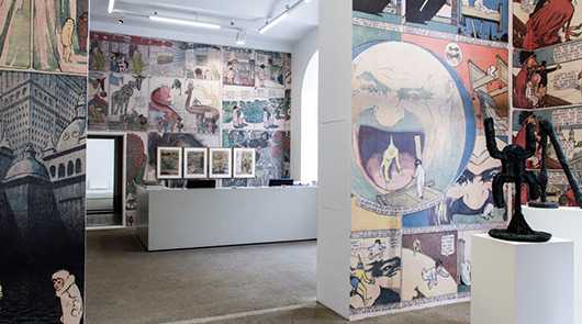Ausstellungen: Kunstausstellung mit Comic-Wandbildern und Skulpturen in einer Galerie.