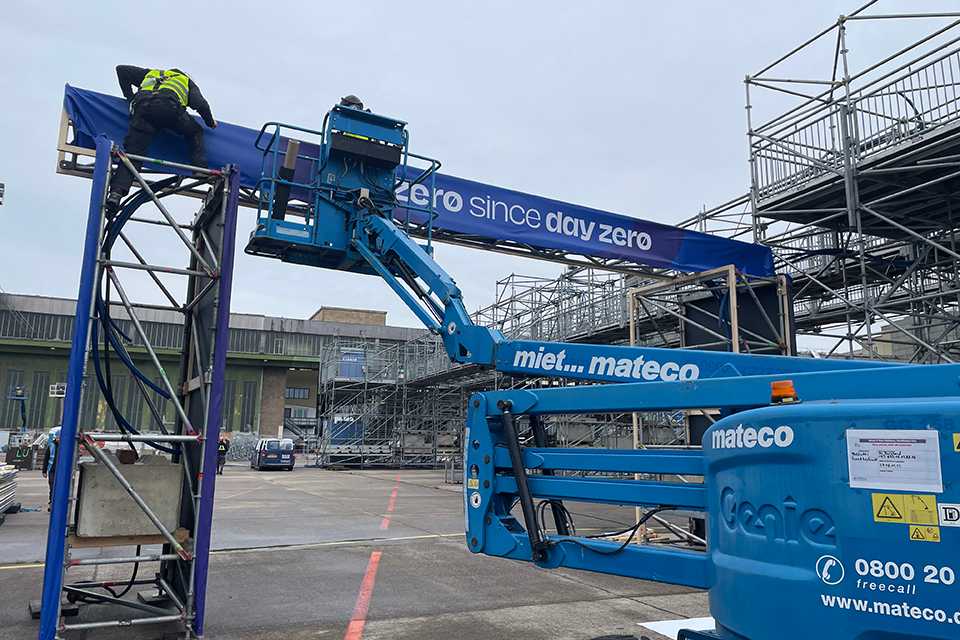 Branding Formula E Berlin 2023: Arbeiter montieren Banner mit Hubsteiger. Eventtechnik im Einsatz.