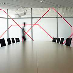 Modernes Büro: Besprechungsraum mit Wandbeklebung, Tisch und Stühlen. Bürodesign.