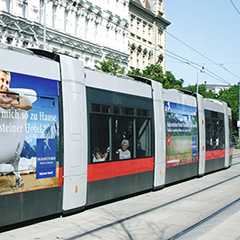 Werbung auf ÖPNV: Straßenbahn mit Hotelwerbung im Stadtbild. Rollende Werbung in Wien.