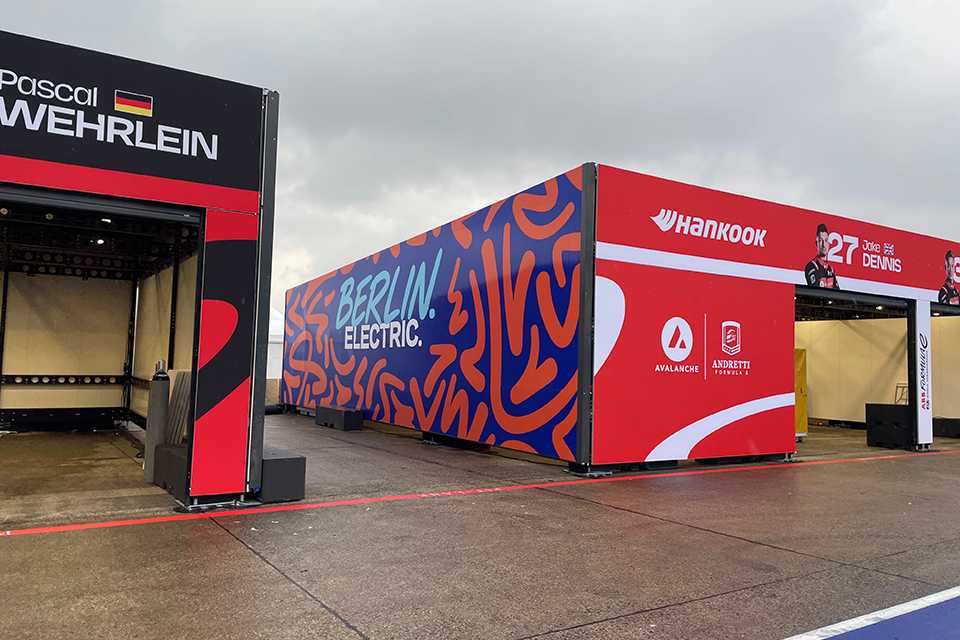 Formula E Branding Berlin 2023: Boxengasse mit Logos und Fahrernamen. E-Rennen in Berlin.