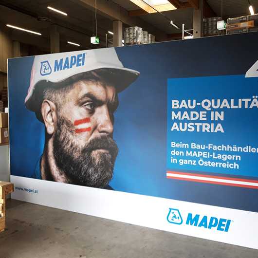 Innenarchitektur: MAPEI Bau-Qualität aus Österreich. Handwerker mit Helm, rot-weiß-rote Flagge.
