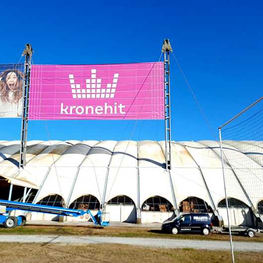 Aussenwerbung: Kronehit Banner (530x530) vor Gebäude. Teaser für Aussenwerbung.