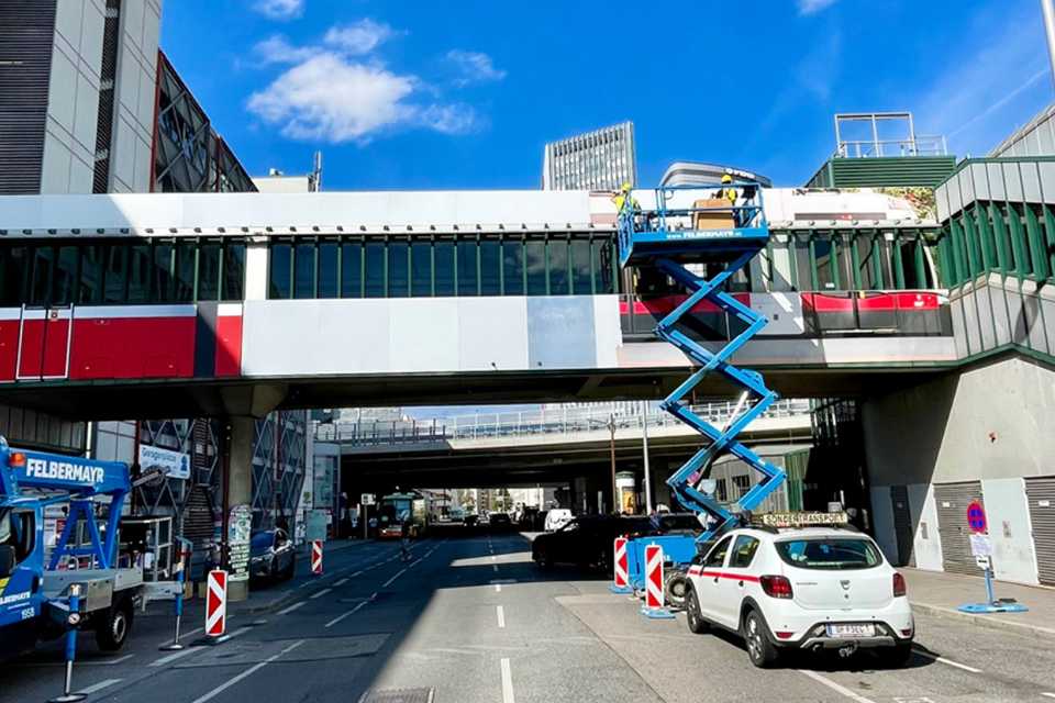 Wiener Linien Branding Steg Erdberg: Arbeiter auf Hebebühne bei Montagearbeiten.