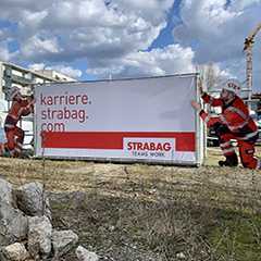 Baustelle Sonderformen: Strabag Banner mit Bauarbeitern. Karriere bei Strabag.com.
