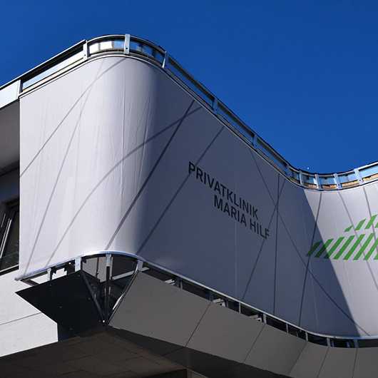 Gebäude: Fassade der Privatklinik Maria Hilf mit Fahrzeugen im Blick.
