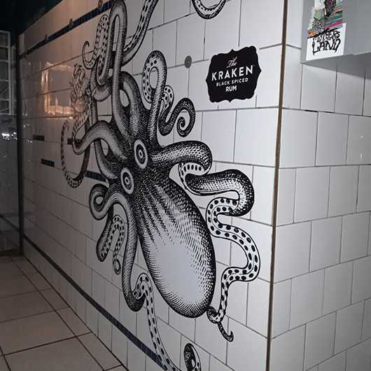 Wandgestaltung: Kraken Rum Interieur mit Oktopus-Motiv auf Fliesen.