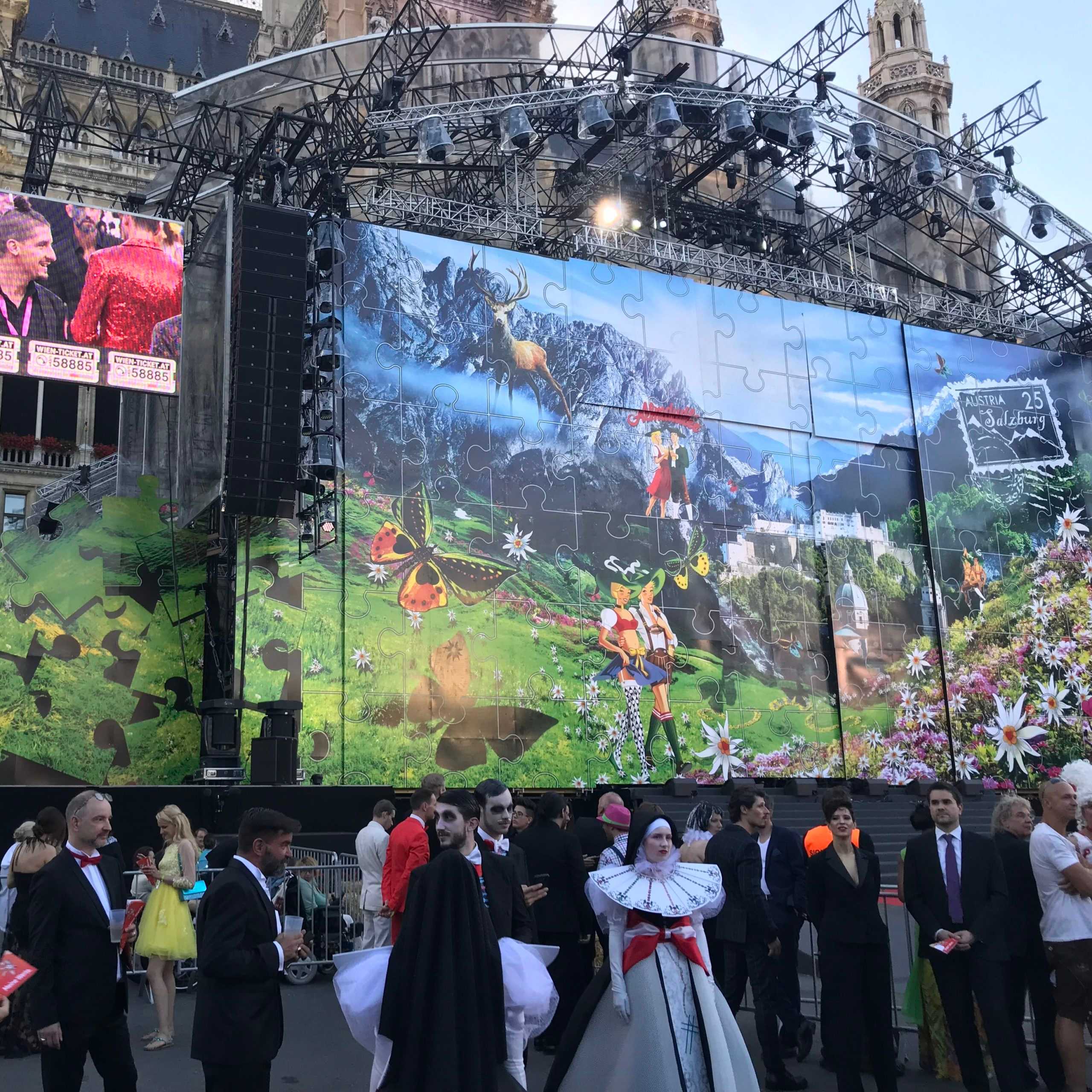 Event in Wien: Bühne mit Puzzle-Motiv, kostümierte Menschen. Kulturveranstaltung in Österreich.