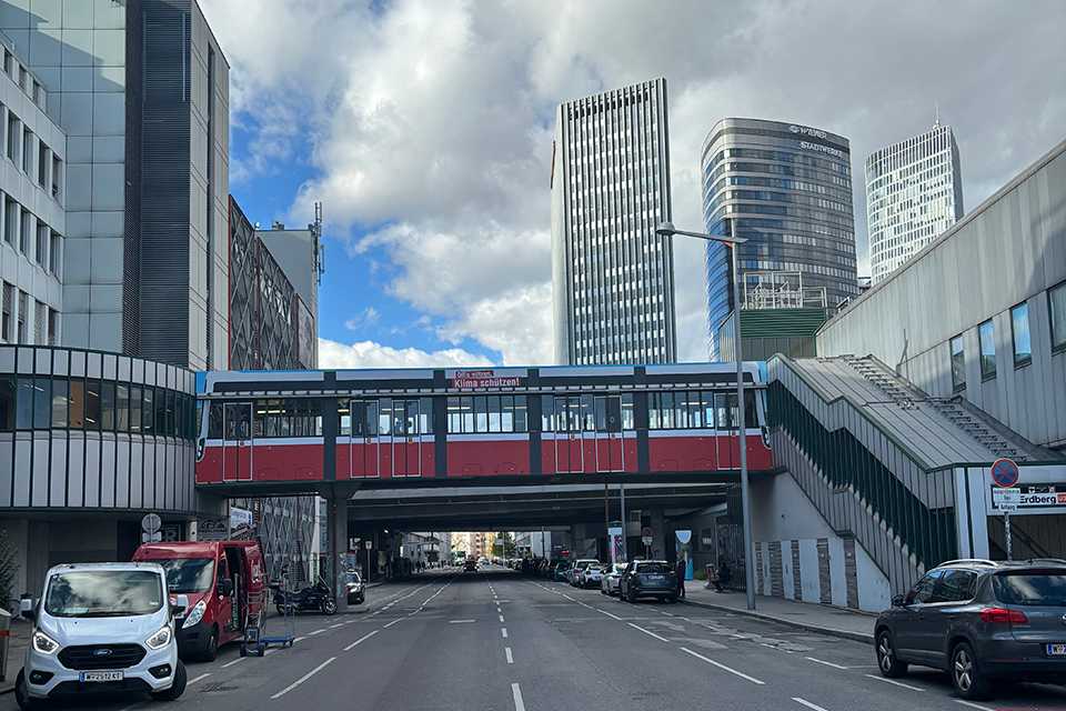 Wiener Linien Steg Erdberg: Roter Übergang mit Skyline. Branding der Wiener Linien.