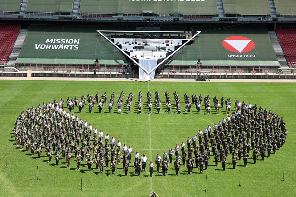 Militärmusik Festival Klagenfurt: Formation der Militärkapelle auf dem Rasen.