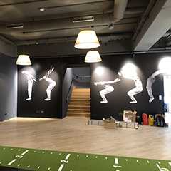 Innenansicht eines Geschäfts/Ladens mit Sportmotiven an der Wand und Treppe.