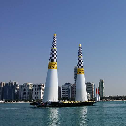 Event Outdoor: Luftrennen-Tore im Wasser vor Skyline. Breitling-Branding.