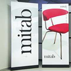 Roll-Up Displays mit MItab Logo und rotem Stuhl. Präsentationssysteme für Messen und Events.