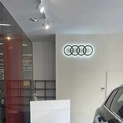 Audi Büro: Beleuchtetes Audi Logo an der Wand. Moderne Büroeinrichtung.