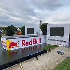 Red Bull Event Gerüst am See. Outdoor Veranstaltung mit LED Bildschirmen.