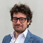 Mag. (FH) Bernhard Hofer Portrait. Mann mit Brille und blauem Sakko.