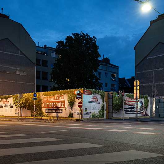 Aussenwerbung Baustelle: Bauzaun mit Klima-Motiven in Wien. Plakatwerbung im urbanen Raum.