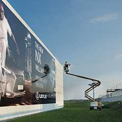 Textile Architektur: Montage einer großen Lexus-Werbefläche im Außenbereich.