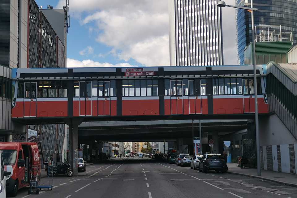 Wiener Linien Steg Erdberg: Rote U-Bahn-Brücke mit Werbebotschaft Öffis nutzen. Klima schützen!.