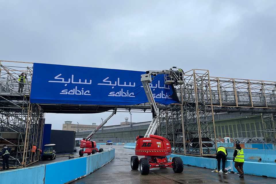 Branding für Formula E Berlin 2023. Aufbau mit Hebebühnen und Gerüst. SABIC Banner.