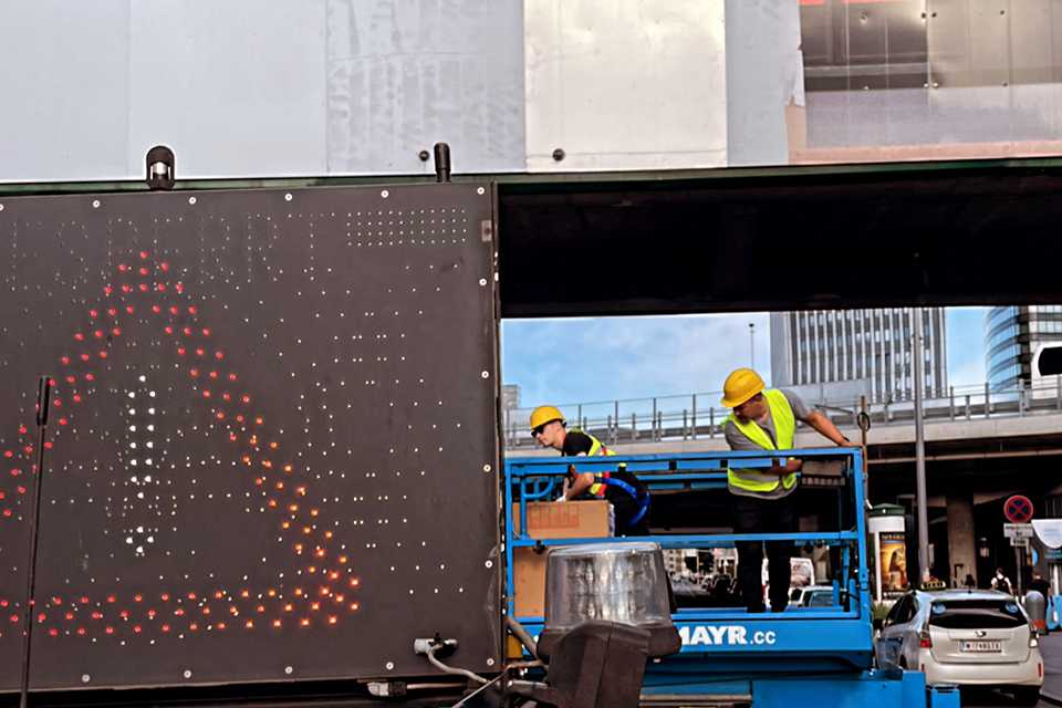 Wiener Linien Branding: Arbeiter am Steg Erdberg mit LED-Anzeige.
