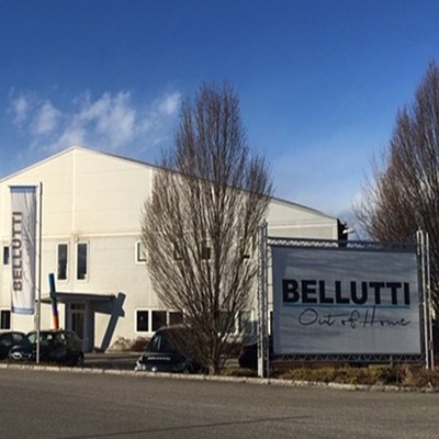 Bellutti Standort KLGFT: Gebäude, Flagge und Werbeschild. Außenansicht bei Tageslicht.